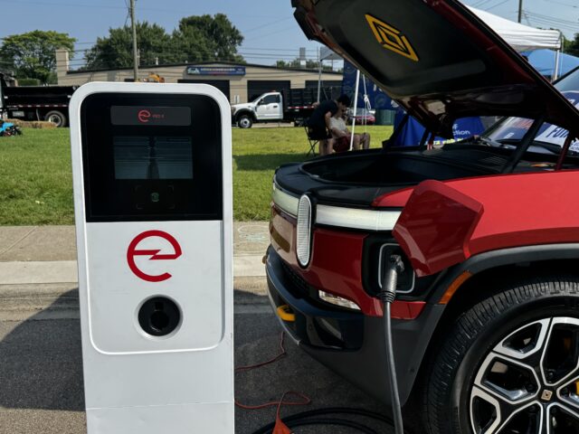 Electric vehicle charging station for eco-friendly transportation, with a red electric car plugged i.