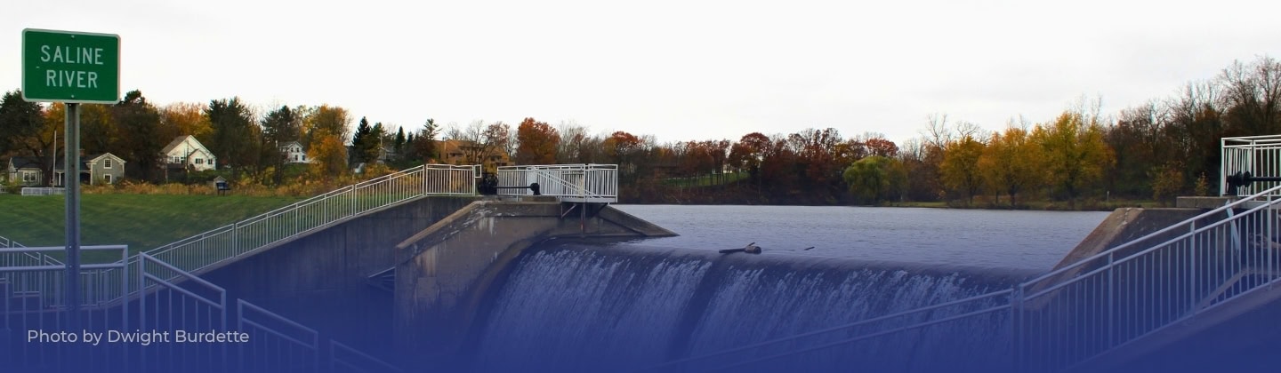 Saline River dam with water flowing, environmental conservation focus.