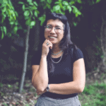 Nancy Morales smiling outdoors in nature.