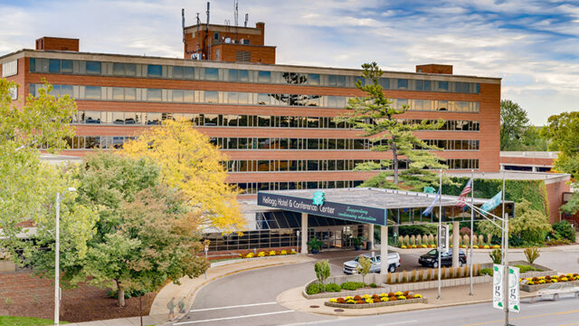Kellogg Center Hotel exterior view with trees and parking area.