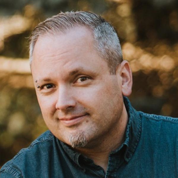 Bob Zammitt portrait - smiling man with short hair and a goatee outdoors.
