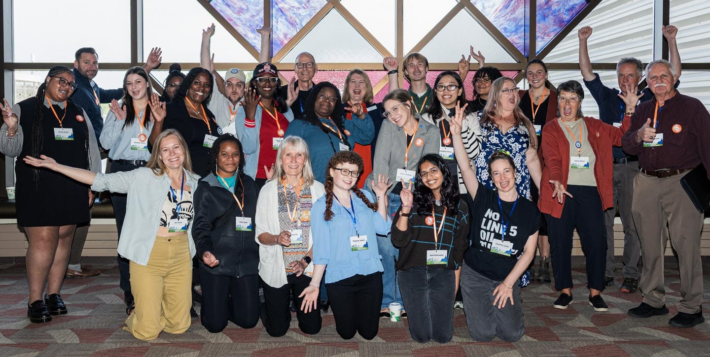 Group of diverse people celebrating climate action at Michigan Climate Action Network event.