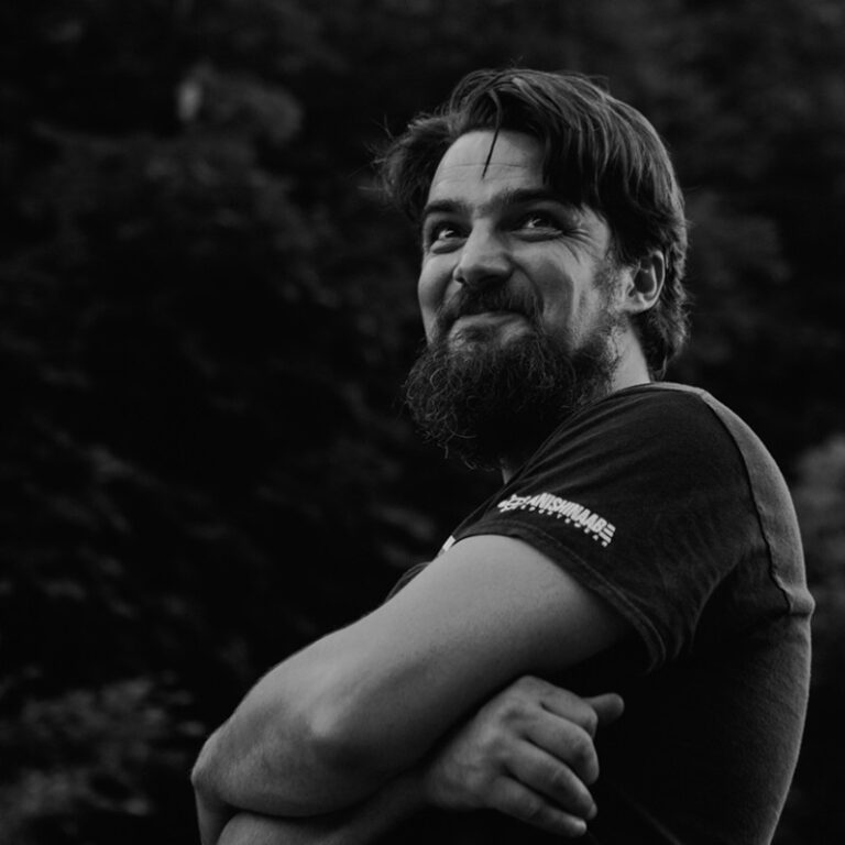 Seth Bernard poses with arms crossed in black and white photo.