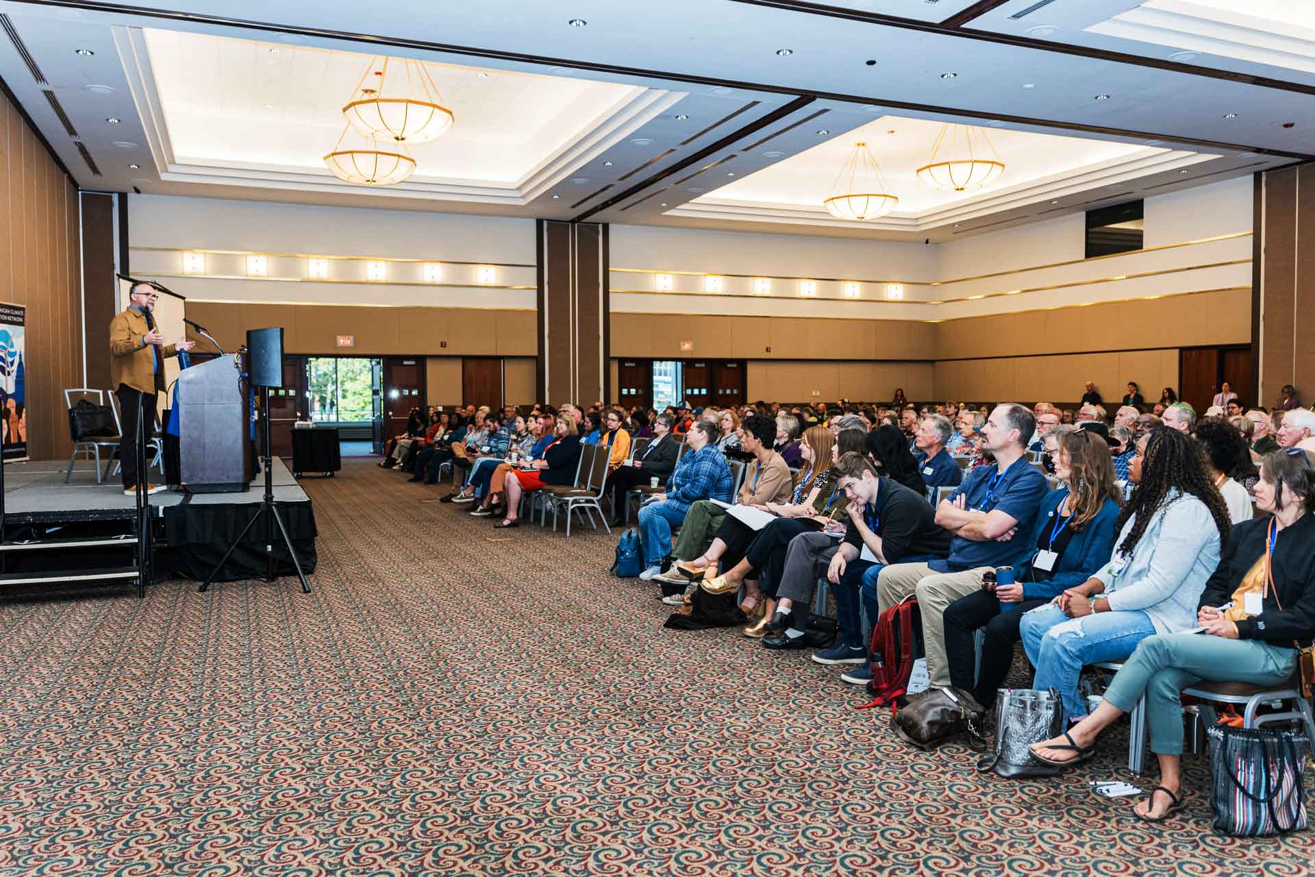 Advocate speaking at Michigan Climate Action Network conference, engaging community on climate change solutions.