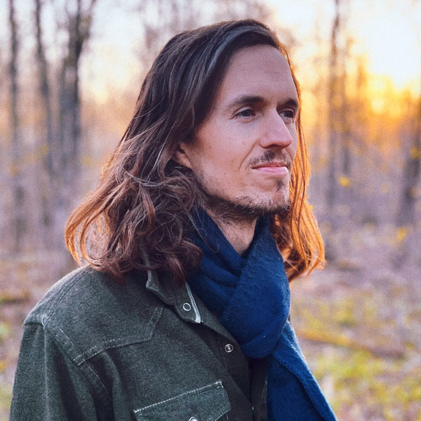Tom Grotewohl outdoor portrait at sunset with trees in the background.