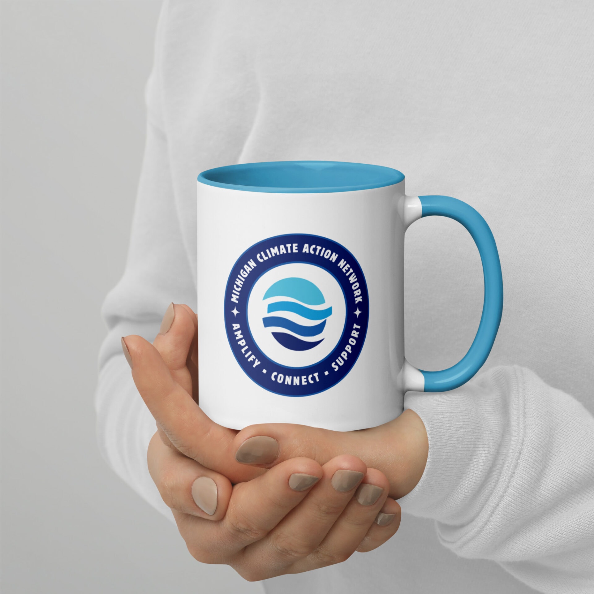 Climate Action Network logo on white mug with blue interior and handle.
